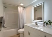 Thumbnail 14 of 39 - A white bathroom with a toilet, sink, and bathtub.