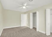 Thumbnail 35 of 39 - A room with a ceiling fan and carpeted floor.