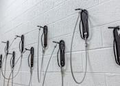 Thumbnail 21 of 67 - A wall of white brick with multiple black and silver hand dryers attached to it.