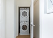 Thumbnail 37 of 67 - A white washing machine and dryer in a small laundry room.