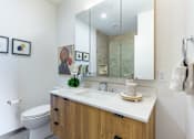 Thumbnail 9 of 67 - A bathroom with a white counter top and a mirror above it.