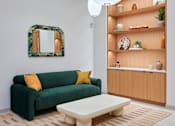 Thumbnail 40 of 67 - a living room with a green couch and a coffee table
