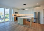 Thumbnail 12 of 67 - a kitchen with an island and a stainless steel refrigerator