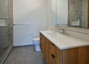 Thumbnail 36 of 67 - a bathroom with a large mirror and a sink and a toilet