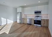 Thumbnail 31 of 67 - a kitchen with white cabinets and stainless steel appliances