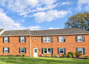 Thumbnail 12 of 12 - A large red brick building with a green lawn in front.