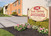 Thumbnail 10 of 12 - A sign for 1300 Park Drive Apartments sits in front of a brick building.