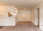 Thumbnail 16 of 20 - A large empty room with a carpeted floor and white walls.