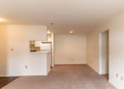 Thumbnail 13 of 20 - A large, empty room with a carpeted floor and white walls.