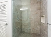 Thumbnail 10 of 67 - A bathroom with a walk-in shower and tiled walls.