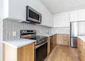 Thumbnail 62 of 67 - A modern kitchen with wooden cabinets and stainless steel appliances.