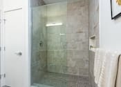 Thumbnail 29 of 67 - A bathroom with a glass shower door and a white door.
