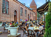 Thumbnail 48 of 67 - people sitting at tables outside of a restaurant