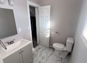 Thumbnail 3 of 23 - A bathroom with a sink, toilet and a mirror.