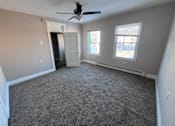Thumbnail 2 of 23 - A room with a ceiling fan and two windows.
