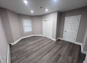 Thumbnail 9 of 23 - A room with a curved wall and wood flooring.