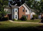 Thumbnail 9 of 10 - A two-story house with a red brick exterior and a white trim.
