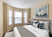 Thumbnail 4 of 10 - A bedroom with a large bed and a painting on the wall.