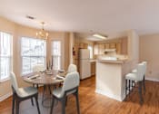 Thumbnail 6 of 9 - A kitchen with a table and chairs in front of a window.