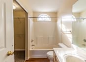 Thumbnail 7 of 10 - A white bathroom with a toilet, sink, and bathtub.