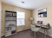 Thumbnail 7 of 9 - A room with a desk, chair, and bookshelf.