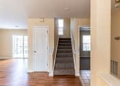 Thumbnail 5 of 9 - A staircase with a carpeted runner leads up to a second floor.