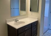 Thumbnail 16 of 19 - A bathroom with a sink and mirror.