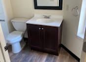 Thumbnail 22 of 23 - A bathroom with a toilet, sink, and mirror.
