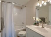 Thumbnail 29 of 48 - A white bathroom with a toilet, sink, and shower.