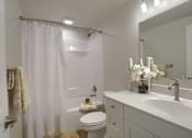 Thumbnail 7 of 48 - A white bathroom with a toilet, sink, and shower.