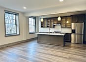 Thumbnail 1 of 15 - a kitchen with a large island in the middle of a wood floor
