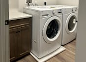 Thumbnail 7 of 15 - a washer and dryer in a laundry room with a sink and cabinets