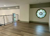 Thumbnail 5 of 15 - an empty living room with a stained glass window on the wall