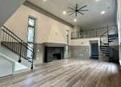 Thumbnail 4 of 15 - a large living room with a fireplace and stairs