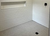 Thumbnail 10 of 15 - a white tiled bathroom with a toilet and a sink