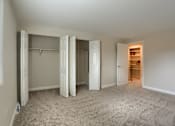 Thumbnail 8 of 48 - A room with a carpeted floor and a closet with white doors.