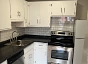Thumbnail 4 of 5 - an empty kitchen with white cabinets and stainless steel appliances