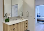 Thumbnail 11 of 67 - A bathroom with a sink, mirror, and rug.