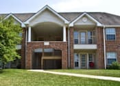 Thumbnail 3 of 20 - A large brick building with a covered walkway in front.