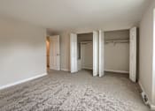 Thumbnail 26 of 48 - A room with carpeted floor and white walls with a doorway leading to another room.