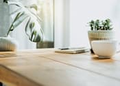 Thumbnail 7 of 7 - a wooden table with a coffee cup and a plant
