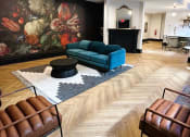 Thumbnail 19 of 26 - a living room with a blue couch and a large painting on the wall