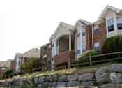 Thumbnail 2 of 20 - A row of houses with a stone wall in front.