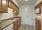 Thumbnail 9 of 16 - Mechanicsburg Apartments | Delbrook Manor Apartments | a kitchen with white appliances and brown cabinets