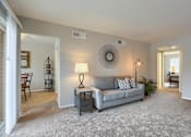 Thumbnail 7 of 16 - Mechanicsburg Apartments | Delbrook Manor Apartments | a living room with a couch and a table with a lamp