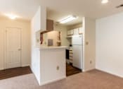 Thumbnail 12 of 20 - A kitchen area with a refrigerator, sink, and cabinets.