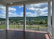 Thumbnail 10 of 19 - A porch with a view of a town and mountains.