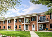 Thumbnail 11 of 12 - A row of red brick houses with green lawns and trees in front.