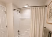 Thumbnail 42 of 48 - A white bathroom with a white tub and a white door.