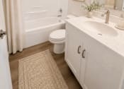 Thumbnail 39 of 48 - A white bathroom with a toilet, sink, and shower.